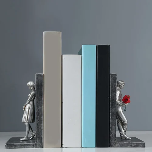 L'ensemble serre livre art nouveau argenté comprend deux serre-livres métalliques, l'un avec une figure féminine regardant vers le bas, l'autre avec une figure masculine tenant une rose rouge. Ces pièces élégantes permettent de maintenir quatre livres sur votre étagère, ce qui est idéal pour les passionnés de lecture ou les amateurs de romans.