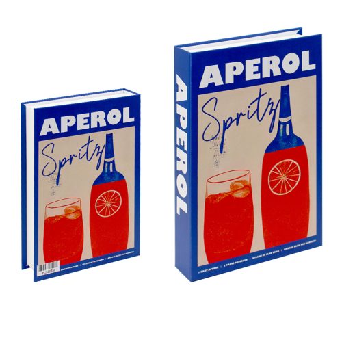 Deux boîtes rectangulaires ressemblant à des livres se tiennent debout comme des accessoires de lecture sur une étagère. Les deux boîtes ont des couvertures bleues représentant un verre à cocktail rouge-orange avec une tranche d'orange et une bouteille bleue. Un grand texte blanc et bleu indique "APEROL Spritz". La boîte de droite est plus grande.