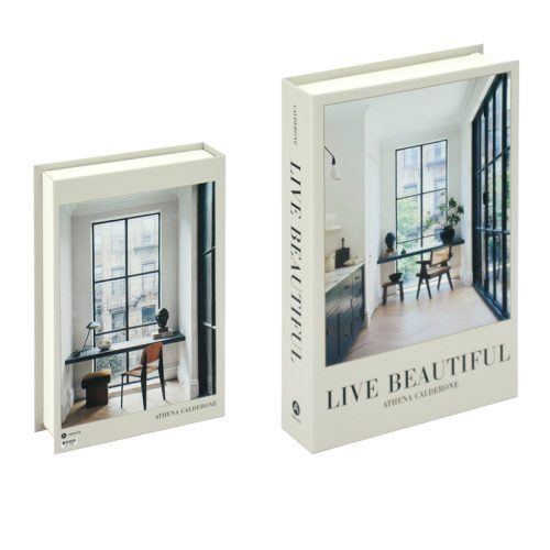 Deux exemplaires du livre Live Beautiful d'Athena Calderone sont présentés. L'un, ouvert sur un bureau minimaliste près d'une grande fenêtre, sert d'Accessoire de lecture ; l'autre est fermé, son titre en gras prêt à orner n'importe quelle étagère.