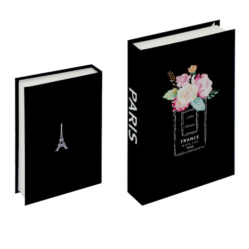 Deux boîtes noires en forme de livre sont présentées. La plus petite boîte est ornée d'une illustration blanche de la Tour Eiffel sur le couvercle. La plus grande boîte présente un bouquet de fleurs roses et blanches dans un flacon de parfum avec l'inscription "France Paris", évoquant le style de la Bibliothèque romaine.