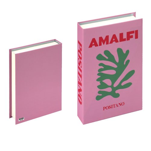 Deux livres roses sont posés debout sur une étagère. Le livre de droite indique AMALFI en grosses lettres rouges, POSITANO en dessous et une illustration de feuille verte en gras sur la couverture. Le livre de gauche a une couverture rose unie et un code-barres au dos.